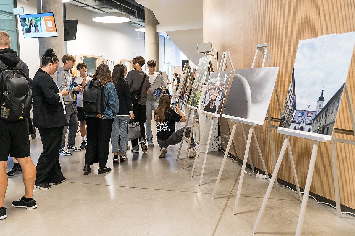 Visitors at the exhibition of the competition photographs on easels