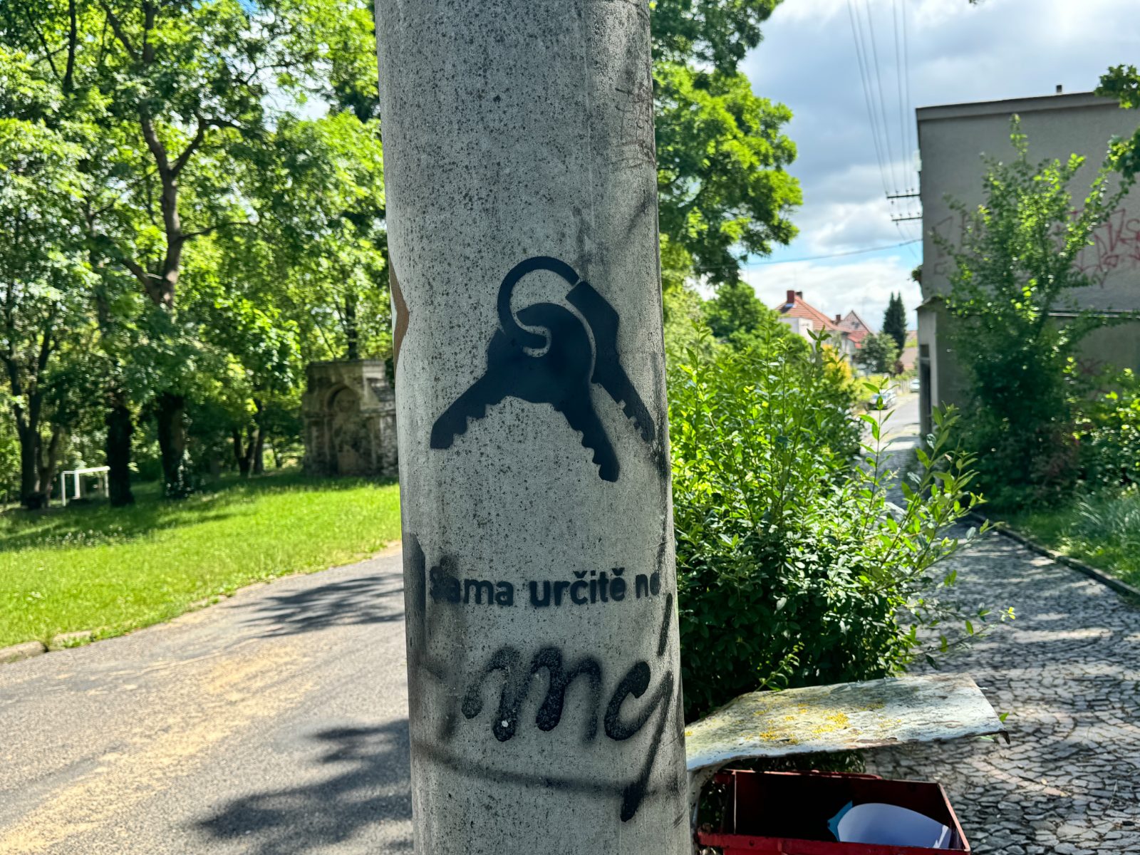 Painted slogan and symbol on a lamp post by a path