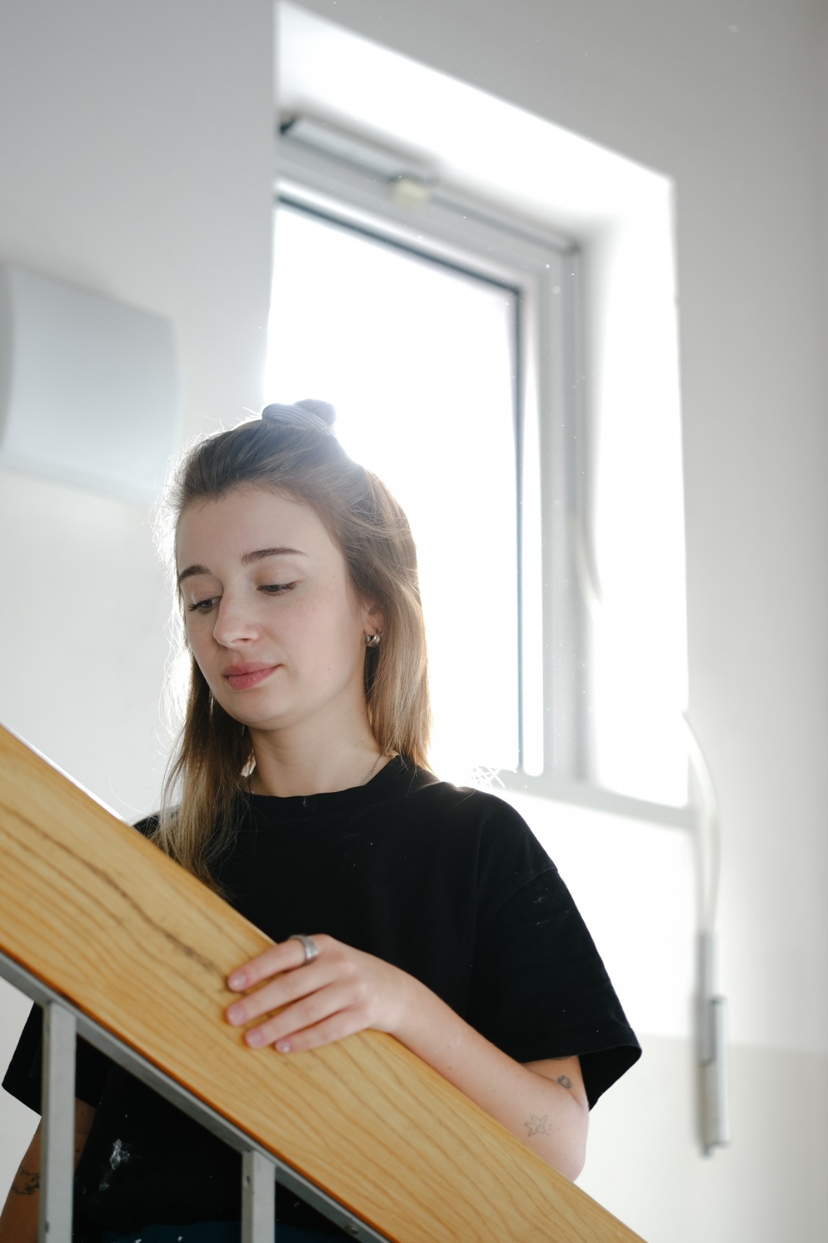 Natálie Sedláčková leaning on a wooden stair railing