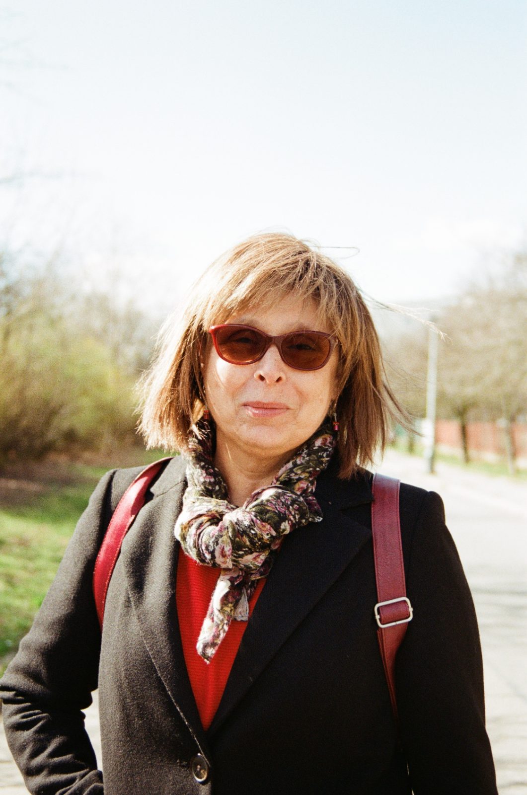 Woman in sunglasses and a patterned scarf on an estate path