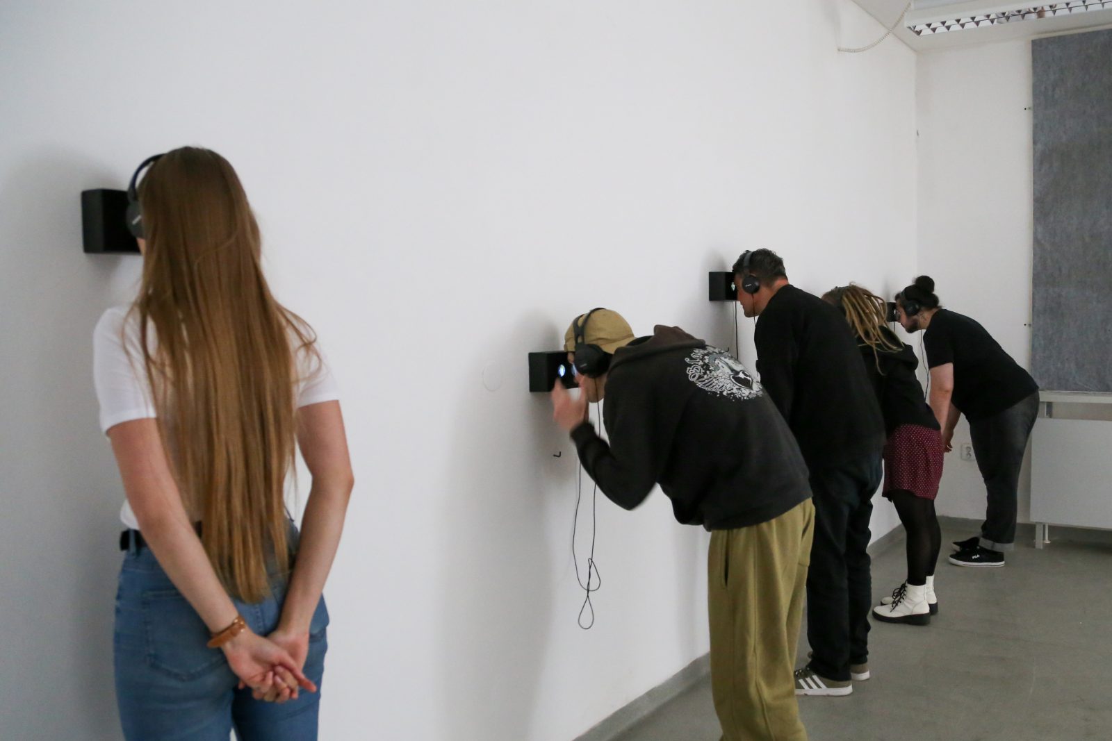 Visitors watching the screens along the gallery wall