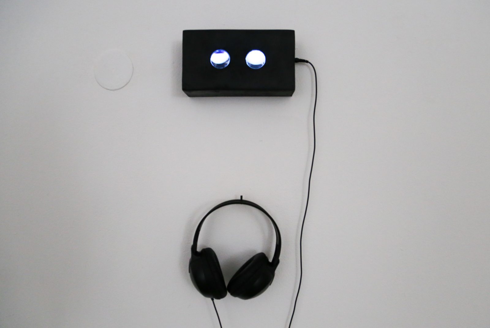 Close-up of a black viewing box with two glowing lenses on the wall