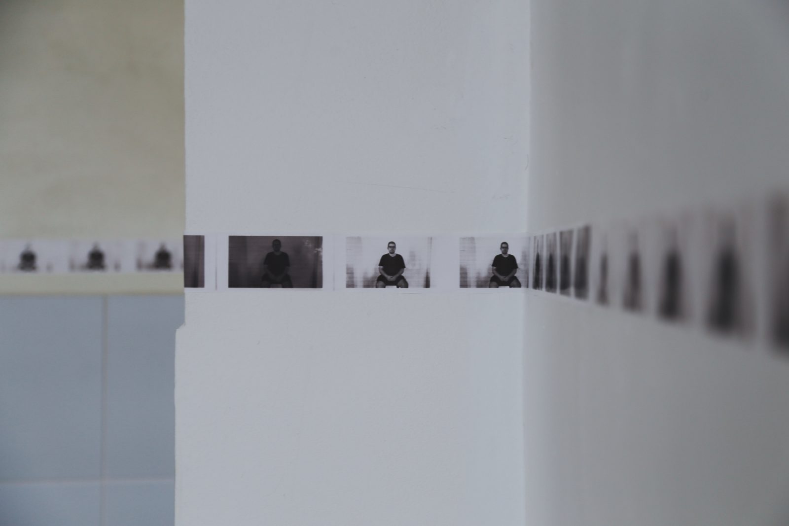 The row of photographs turning a corner of the room